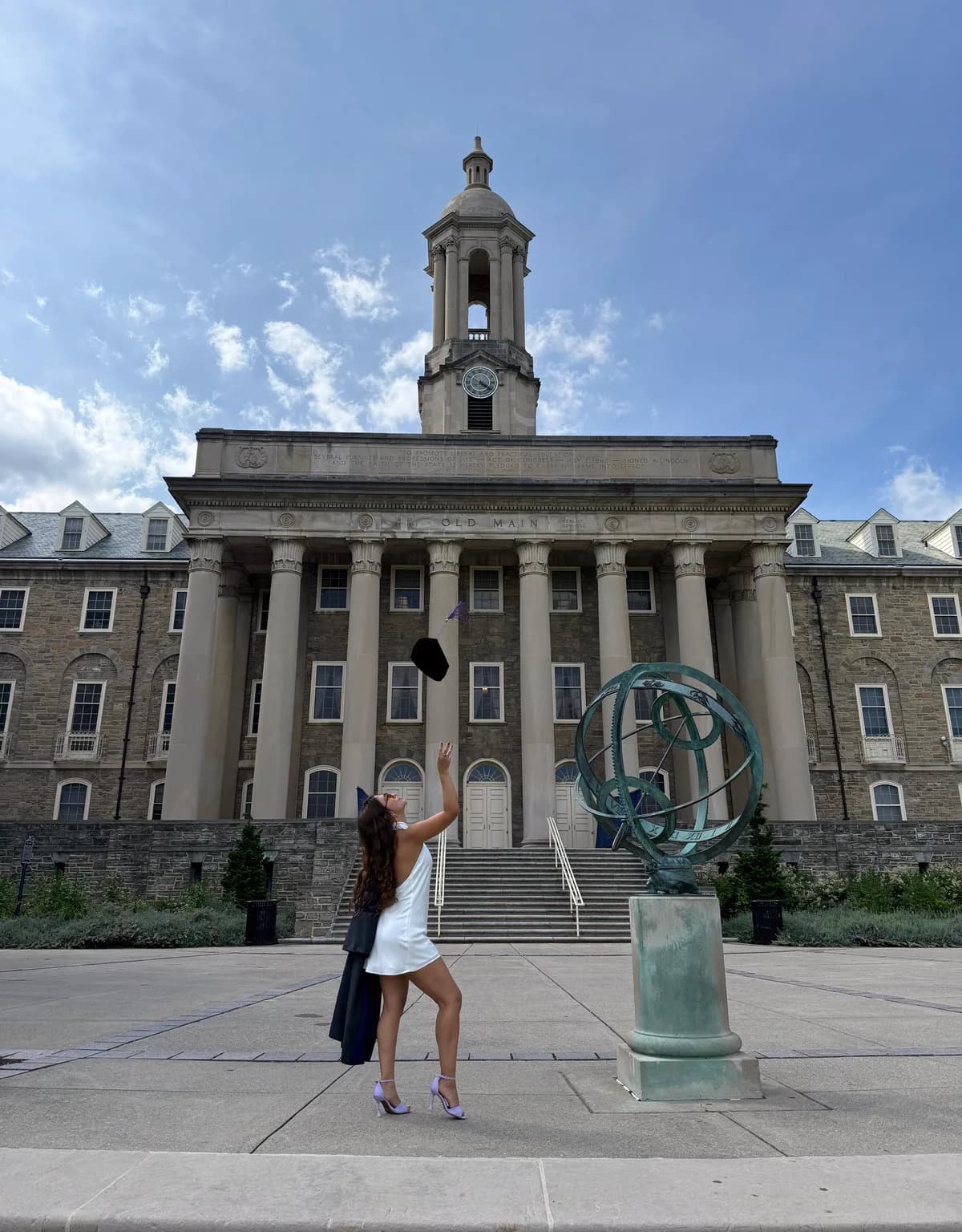 Daniella Hernández lanzando el birrete frente a Old Main, Penn State.