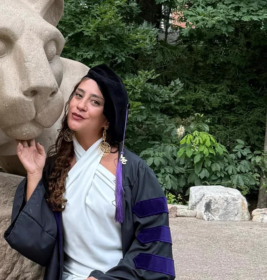 Daniella Hernández in doctoral regalia: velvet tam and the purple bars of the faculty of law.