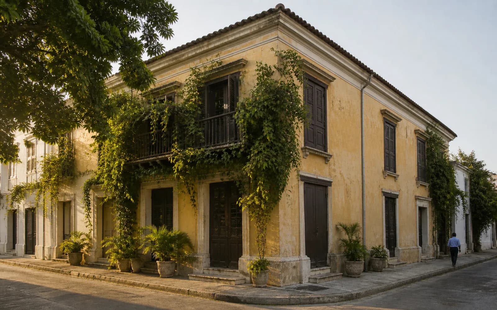 A colonial corner facade in Santa Marta, with a wrought-iron balcony and tall shuttered doors.