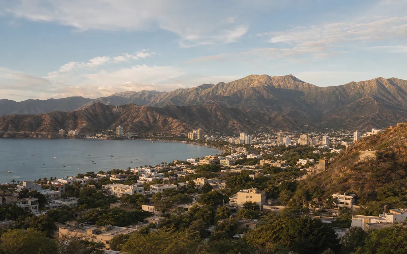 Santa Marta in late afternoon light, with the bay and the Sierra Nevada behind it.